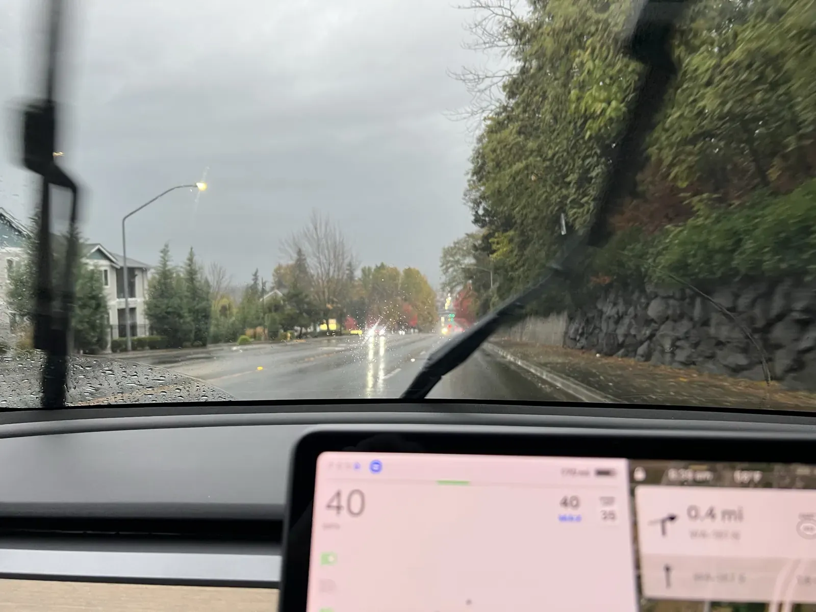 View over the dash on a rainy street with the driving visualization on screen